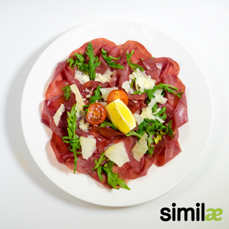 Carpaccio de bresaola con grana padano, tomates y rucola